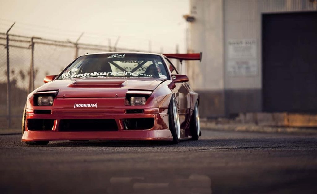 Red Mazda RX-7 FC widebody JDM drift car with pop-up headlights in golden hour light Wallpaper