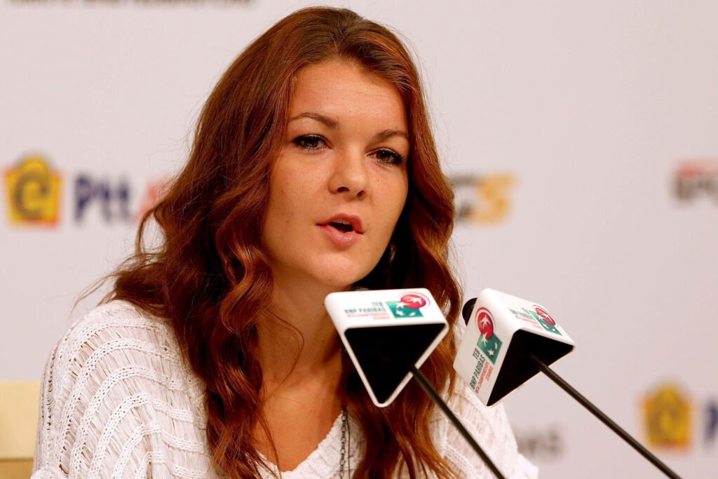 Agnieszka Radwańska speaking at press conference with microphones in professional event setting Wallpaper