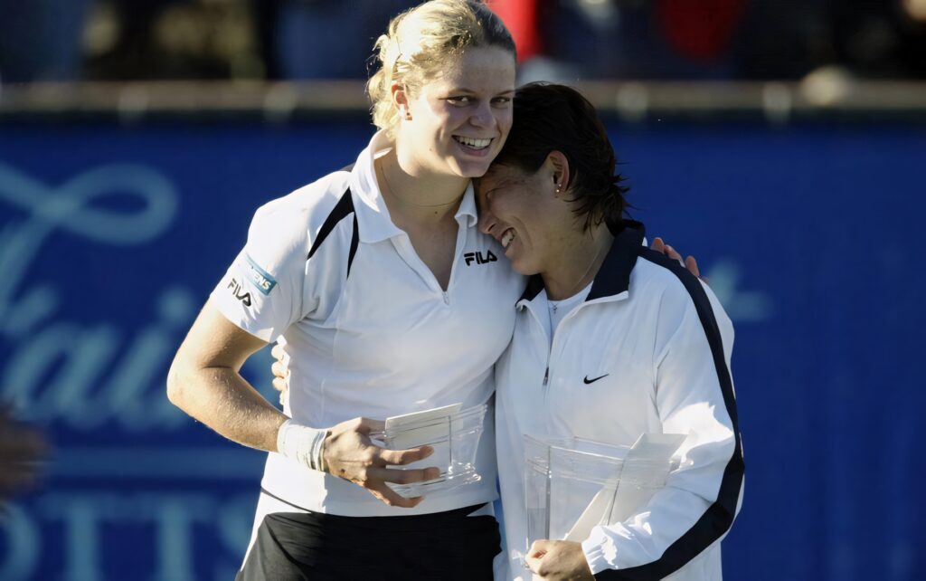 Ai Sugiyama hugging fellow tennis player on court smiling holding trophies celebrating friendship Wallpaper