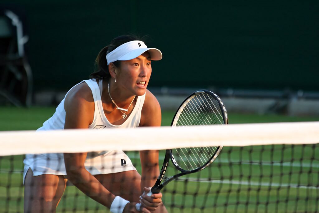 Ai Sugiyama focused in ready position near net during intense tennis match wallpaper background
