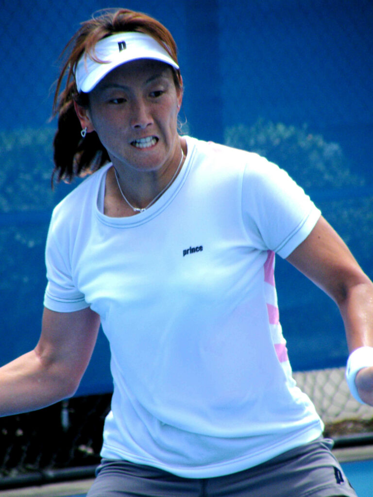 Ai Sugiyama focused and determined playing tennis match dynamic sports wallpaper background