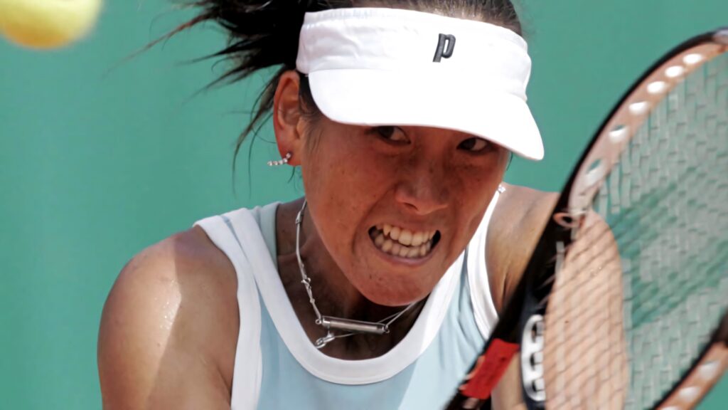 Closeup of Ai Sugiyama focused in tennis match preparing to return shot with determination wallpaper