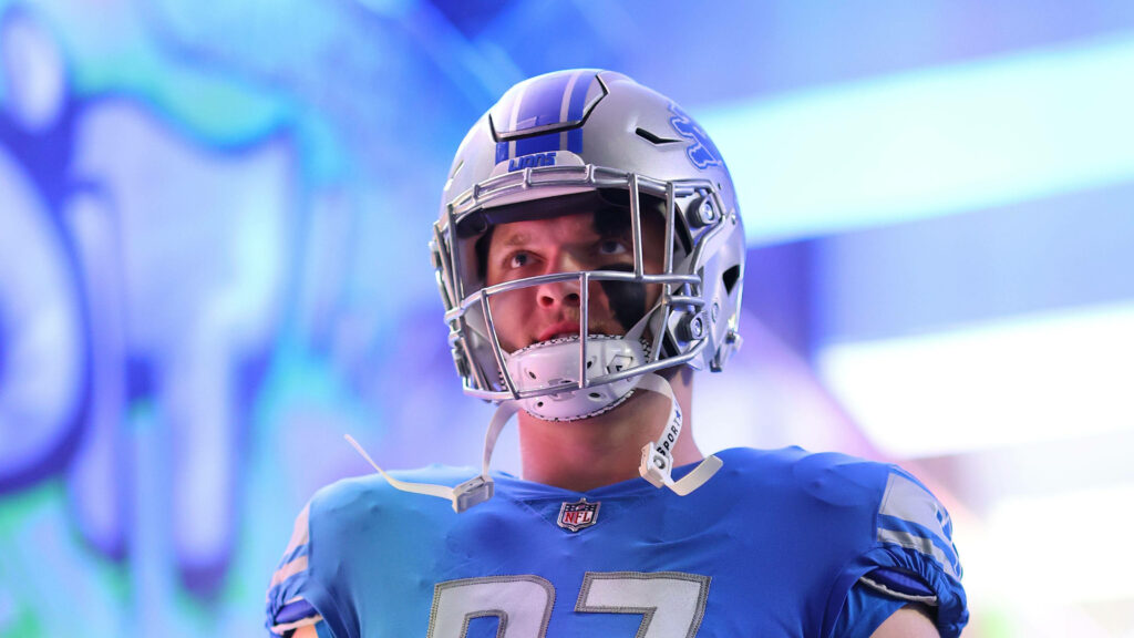 Detroit Lions defensive end Aidan Hutchinson in uniform with intense focus vibrant lighting wallpaper