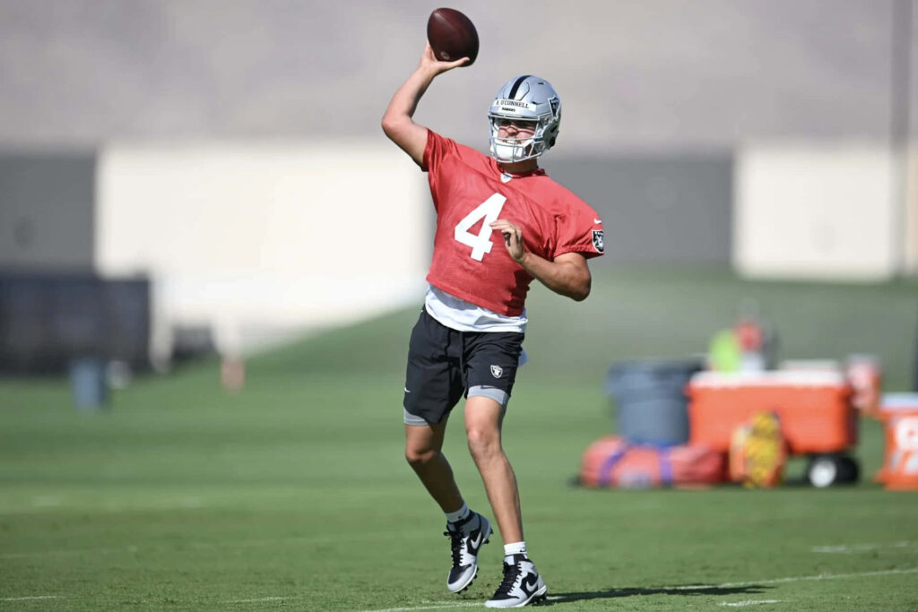 Aidan OConnell practicing quarterback throwing technique during intense football training session Wallpaper