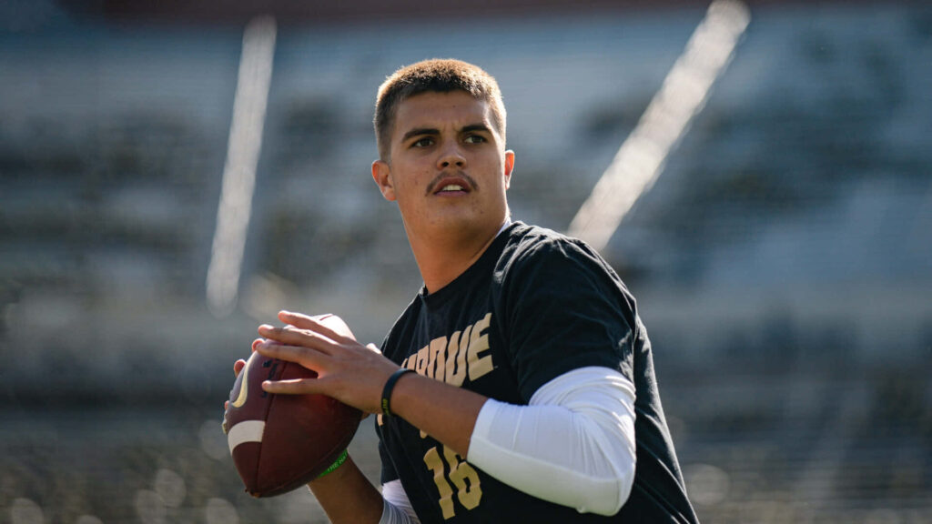 Aidan OConnell in Purdue uniform ready to throw football showing quarterback focus and determination Wallpaper