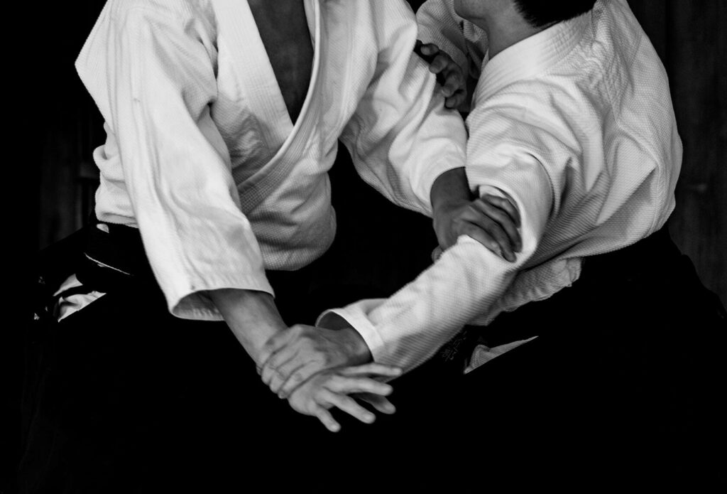 Two Aikidoka demonstrating fluid traditional Aikido technique in martial arts training wallpaper