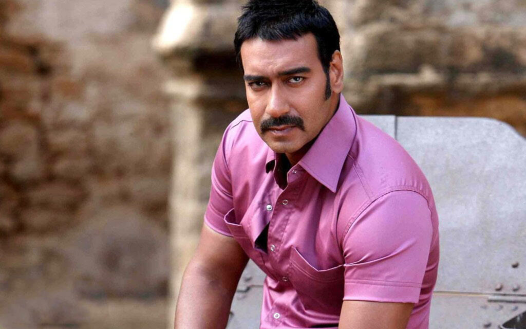 Ajay Devgn in pink shirt outdoors serious expression stylish charismatic wallpaper background