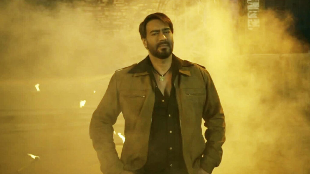 Ajay Devgn in brown jacket with dramatic golden haze intense stylish wallpaper background