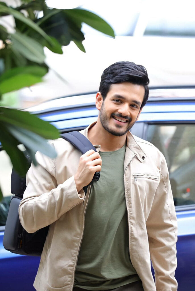 Akhil Akkineni smiling in casual outfit carrying backpack with relaxed approachable vibe wallpaper