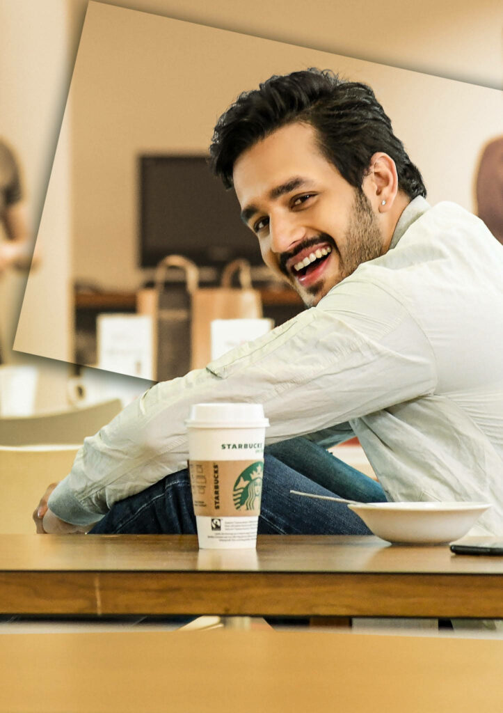 Akhil Akkineni smiling at café with Starbucks coffee cup and wallpaper background relaxing