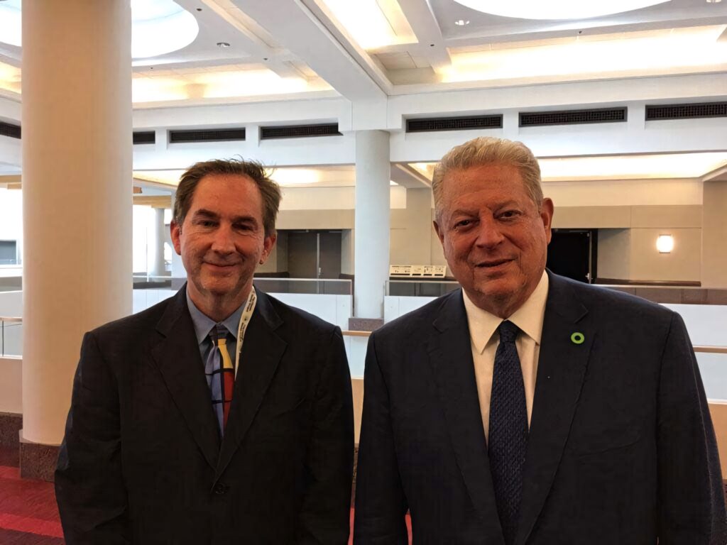 Al Gore and meteorologist Paul Huttner discuss climate change in a bright modern building interior Wallpaper
