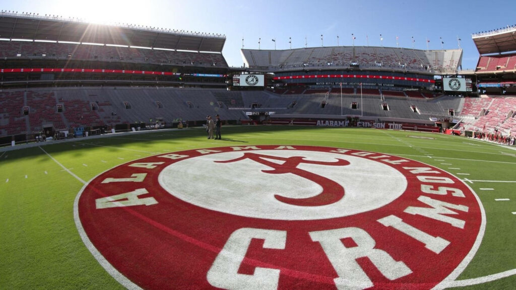 Alabama Crimson Tide football field with center logo and stadium stands under clear blue sky Wallpaper