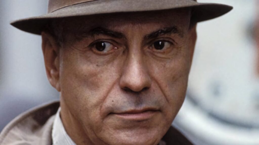 Close-up of Alan Arkin as George Kraft wearing fedora with intense thoughtful expression wallpaper