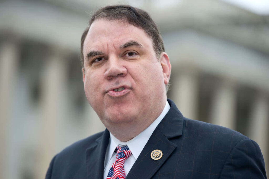 Alan Grayson American politician serious expression pouty lips government buildings background wallpaper