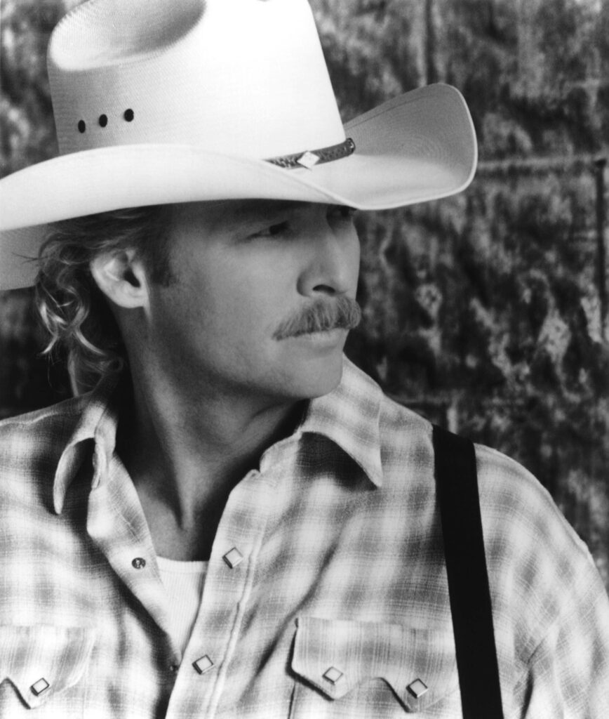 Grayscale side profile of Alan Jackson in cowboy hat and plaid shirt on rustic textured background Wallpaper