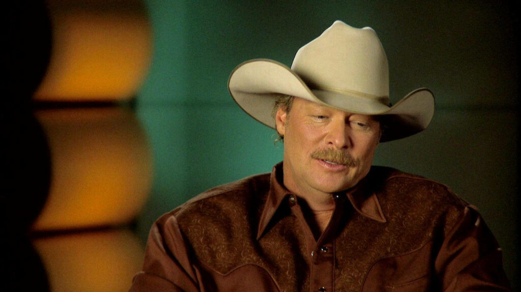 Alan Jackson wearing cowboy hat and western shirt in intimate interview with soft lighting background Wallpaper