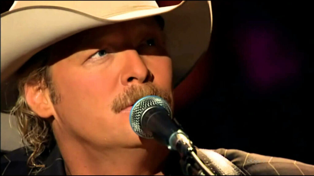 Alan Jackson singing on stage wearing cowboy hat and mustache country music wallpaper background