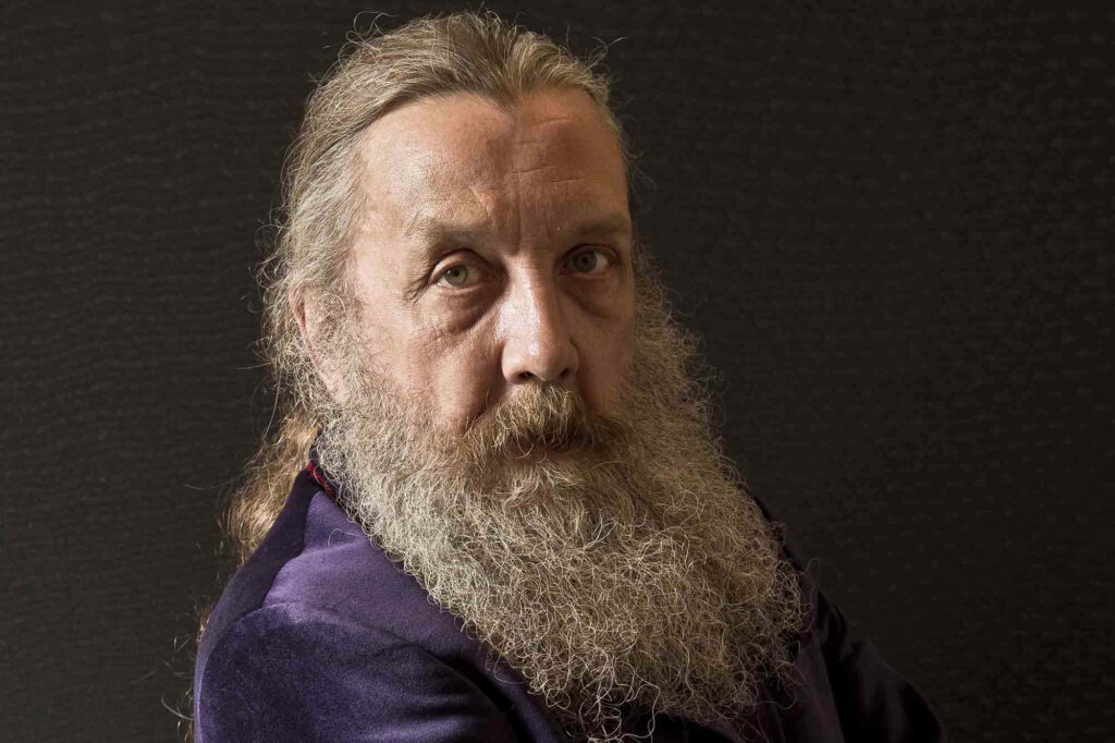 Portrait of Alan Moore visionary writer with long beard intense gaze dark textured background wallpaper