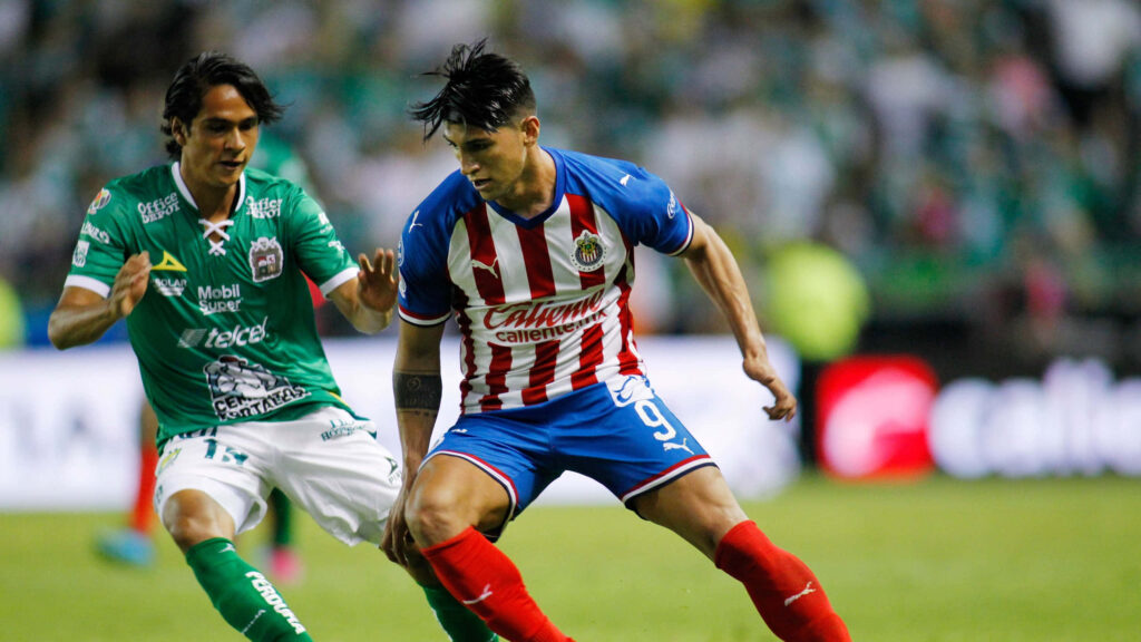 Alan Pulido battles for soccer ball showing skill and determination in intense match wallpaper