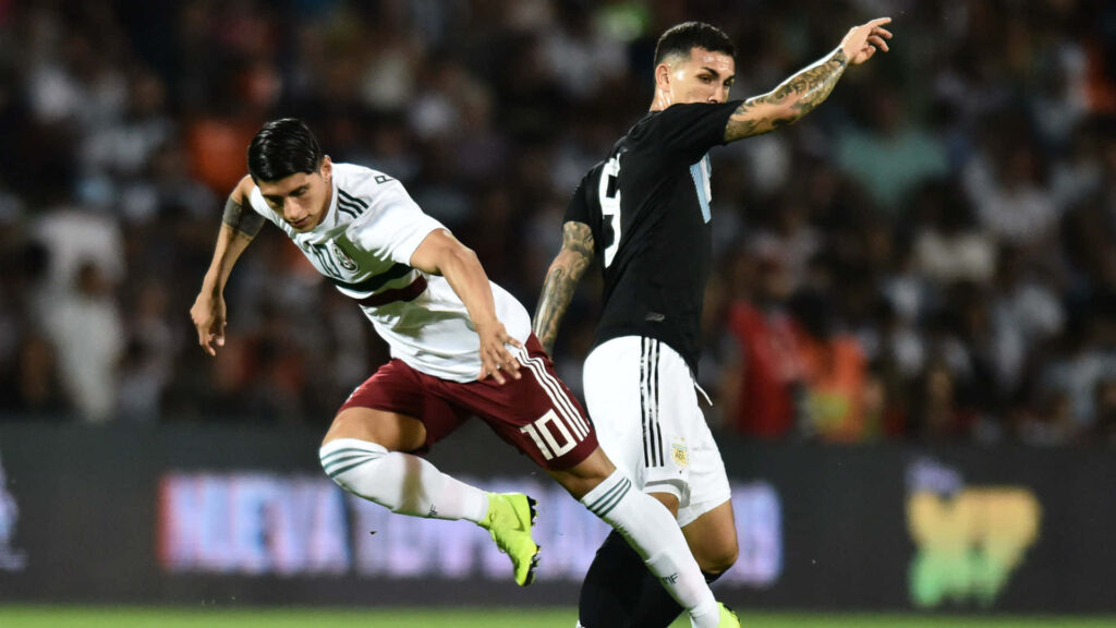 Alan Pulido making intense soccer steal showcasing determination athleticism wallpaper background