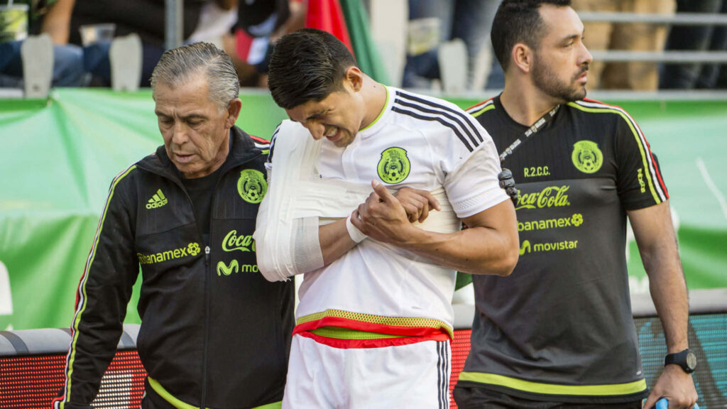 Alan Pulido walks off field injured arm in sling Mexican national team jersey with medical staff Wallpaper