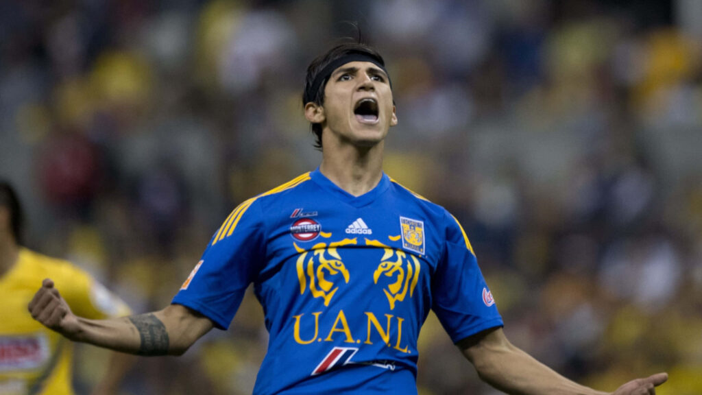 Alan Pulido celebrating goal in UANL Tigres jersey on field intense emotion victory wallpaper