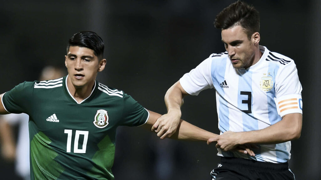 Alan Pulido and Nicolas Tagliafico fight for the ball in Mexico vs Argentina football match wallpaper