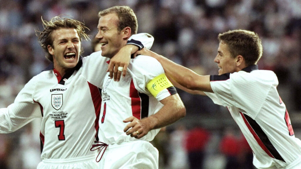 Alan Shearer celebrates with England football teammates showing unity and excitement on field Wallpaper