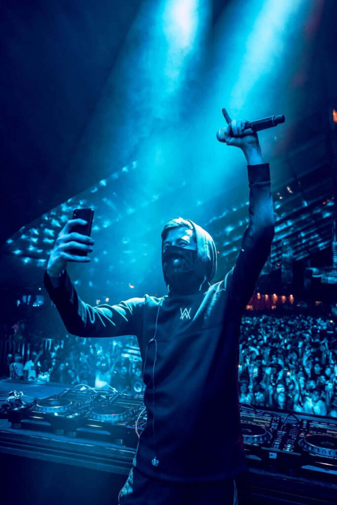 DJ Alan Walker's Electrifying Performance Under Dynamic Blue Lighting Wallpaper