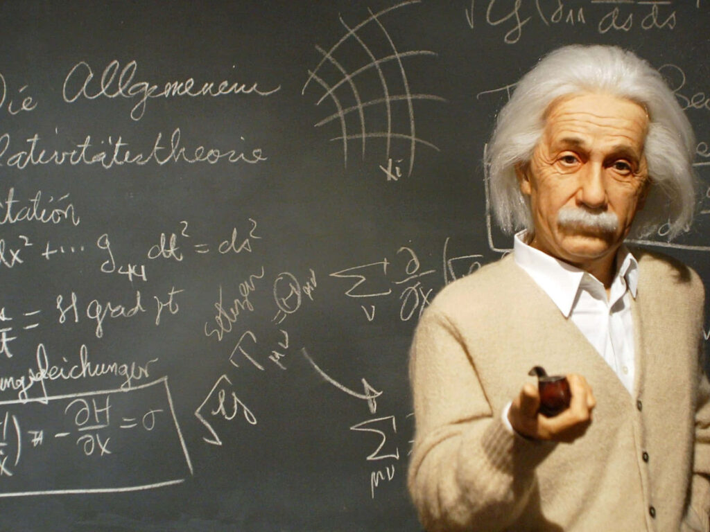 Albert Einstein in front of chalkboard with complex equations inspiring science and physics background Wallpaper