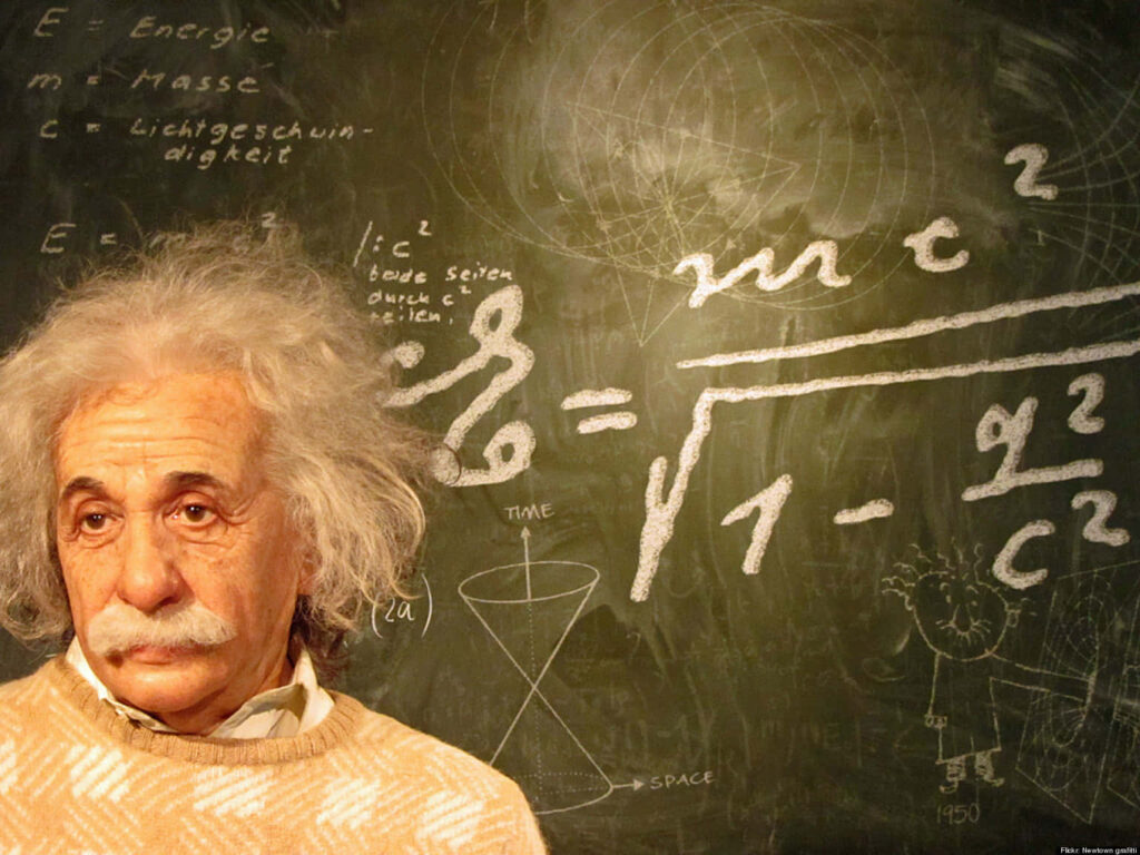 Albert Einstein by chalkboard with relativity physics equations wallpaper background in classic style