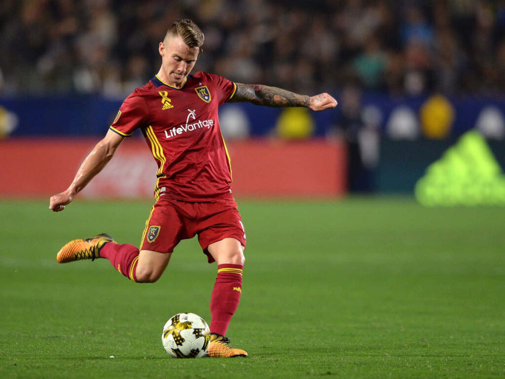 Albert Rusnák mid-kick during Real Salt Lake match versus Portland Timbers on soccer field Wallpaper
