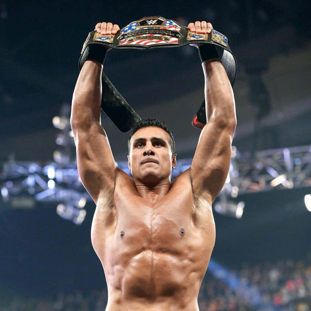 Alberto Del Rio holds wrestling championship belt high in ring showing victory and strength wallpaper