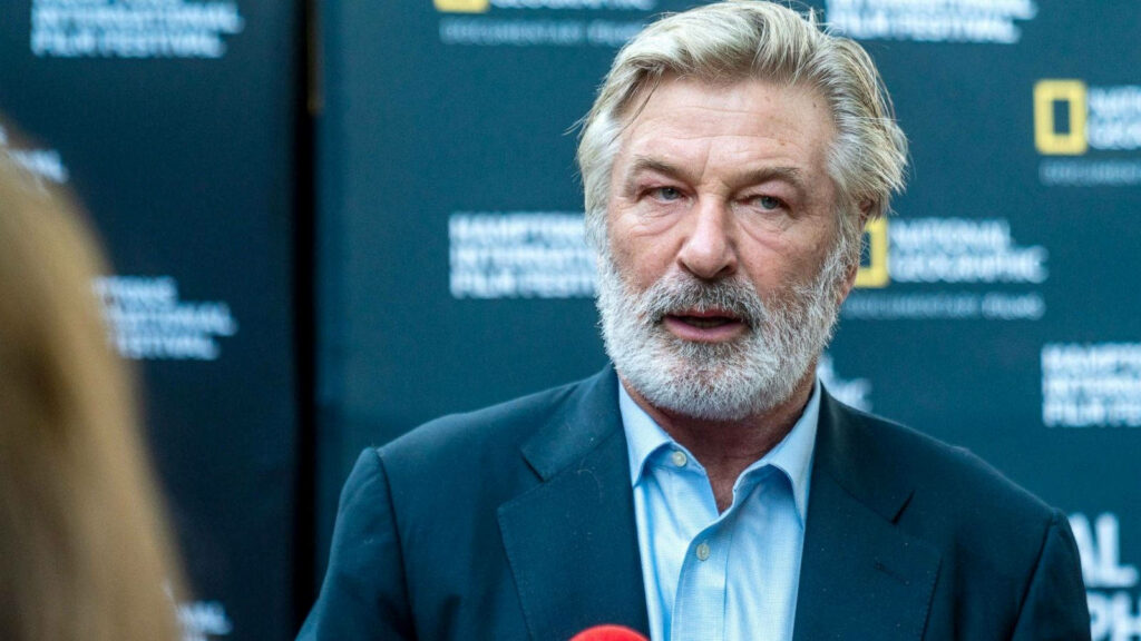 Alec Baldwin with well-groomed beard wearing suit at National Geographic event backdrop wallpaper