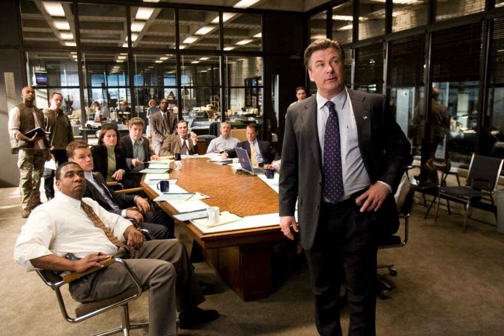 Alec Baldwin leads intense high stakes meeting in conference room scene from The Departed movie Wallpaper