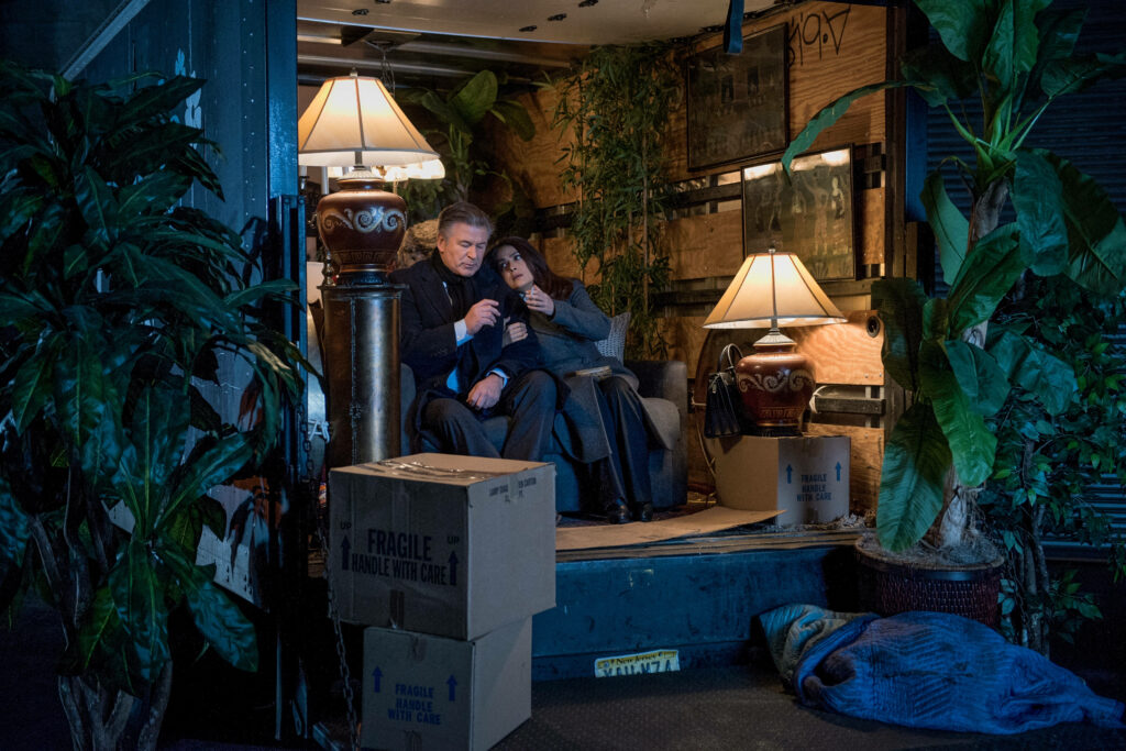 Alec Baldwin in emotional film scene inside dim room with moving boxes and houseplants wallpaper background