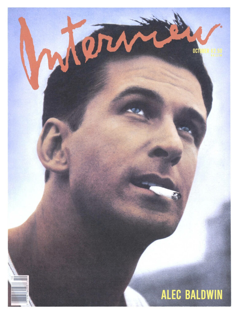 Alec Baldwin on Interview magazine cover looking upward with cigarette against muted background Wallpaper