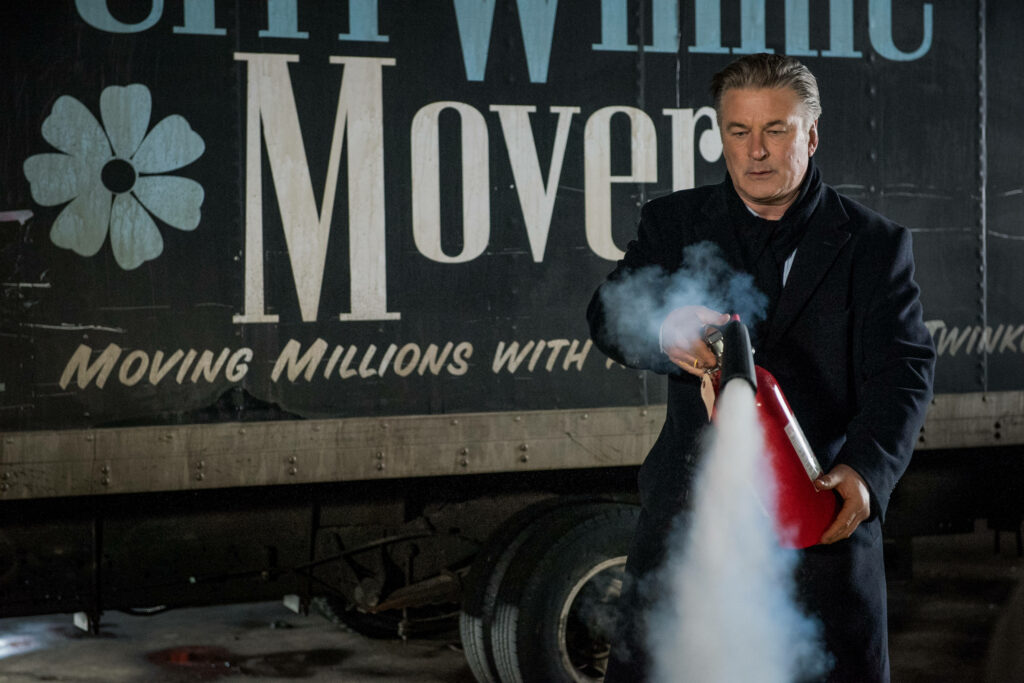 Alec Baldwin as Frank uses fire extinguisher near moving truck in dramatic Drunk Parent scene Wallpaper