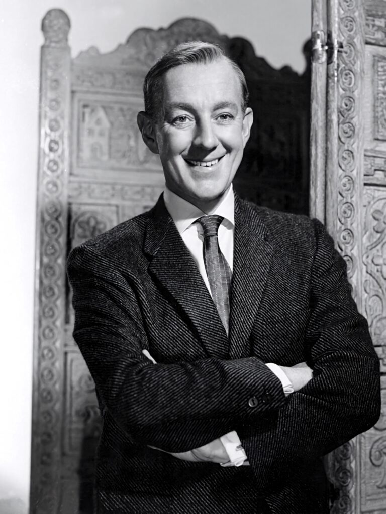 Young Alec Guinness in tweed suit classic monochrome wallpaper with ornate wooden backdrop