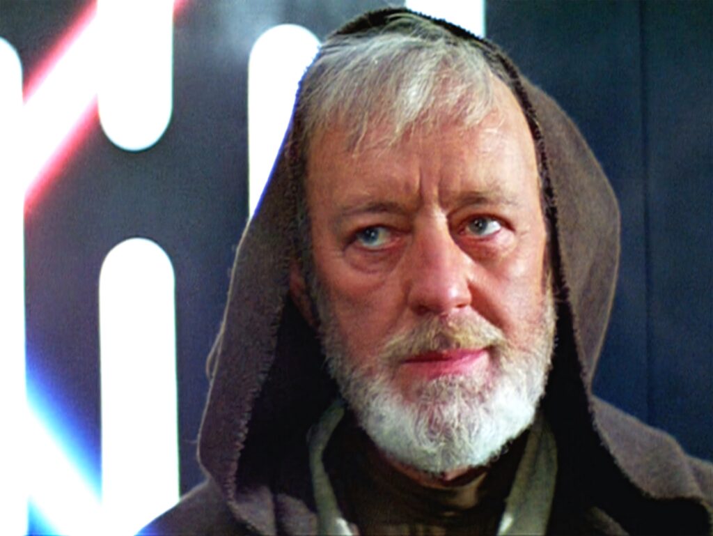 Alec Guinness as Obi Wan Kenobi in brown robe with thoughtful expression sci fi wallpaper background