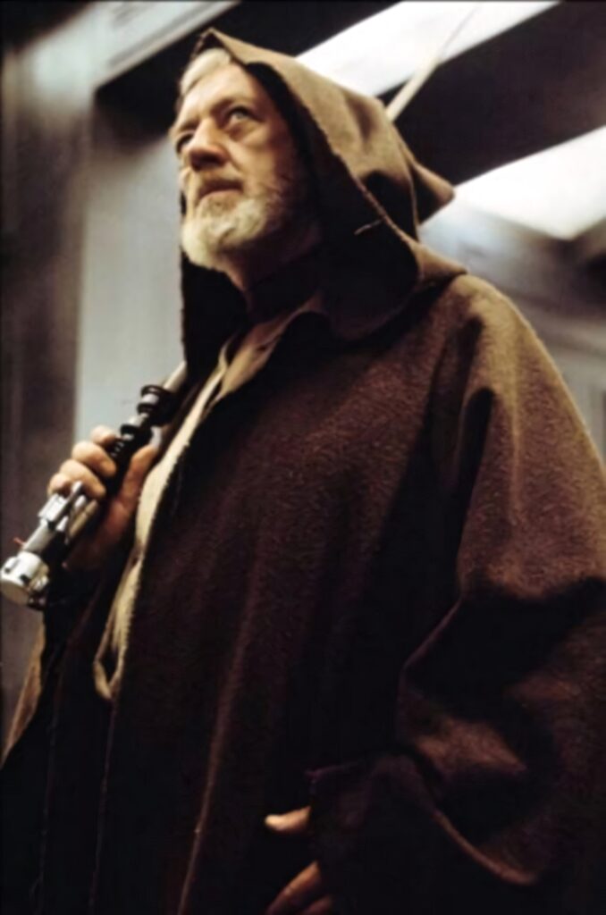 Alec Guinness as Obi-Wan Kenobi in Jedi robe holding lightsaber iconic Star Wars wallpaper