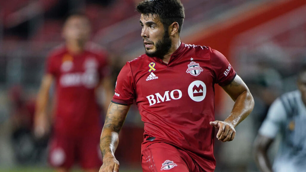 Alejandro Pozuelo in Toronto FC kit showing skill and focus during dynamic soccer match action Wallpaper