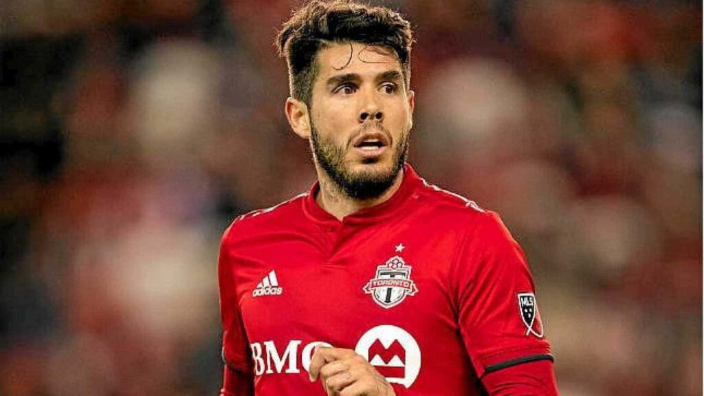 Alejandro Pozuelo in Toronto FC red kit focused during soccer match wallpaper background