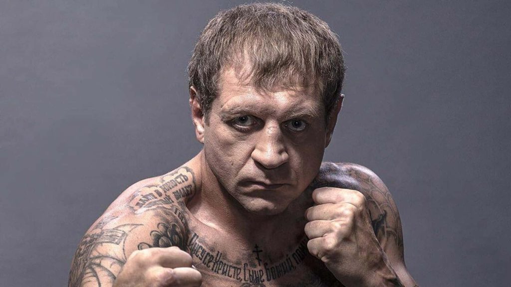 Intense portrait of Russian MMA fighter Aleksander Emelianenko with tattoos in fighting stance Wallpaper
