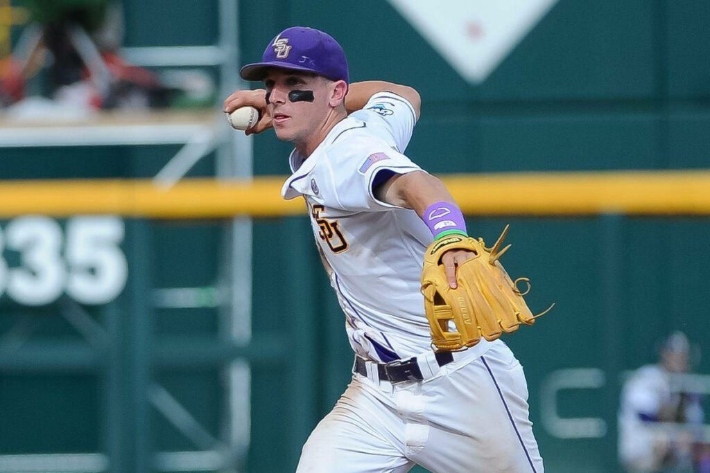 Alex Bregman in LSU baseball uniform holding ball on field action wallpaper background