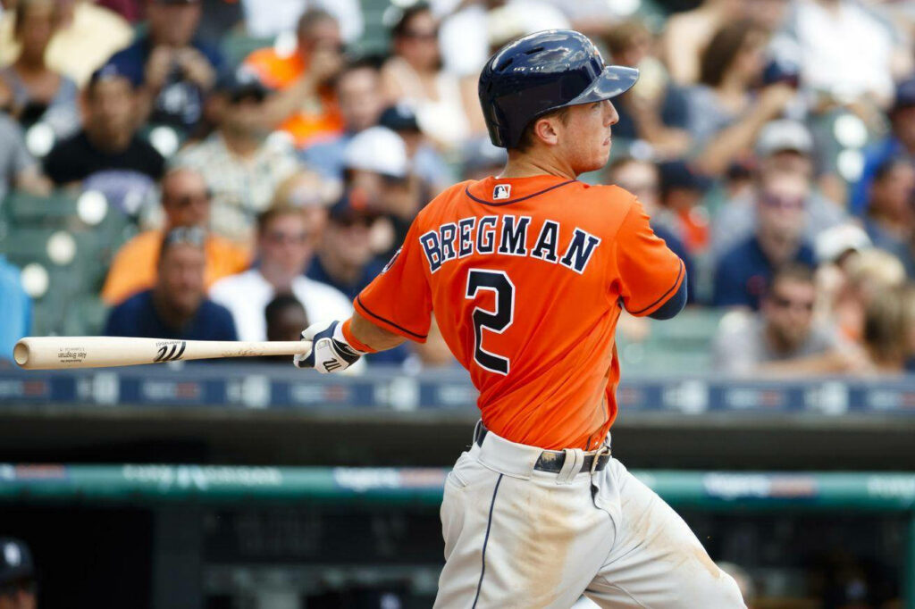 Alex Bregman swinging baseball bat in orange jersey focused at plate during game wallpaper background