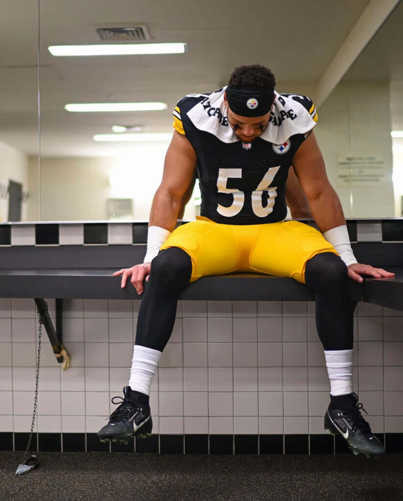 Alex Highsmith in football uniform deep in thought in locker room reflecting determination wallpaper