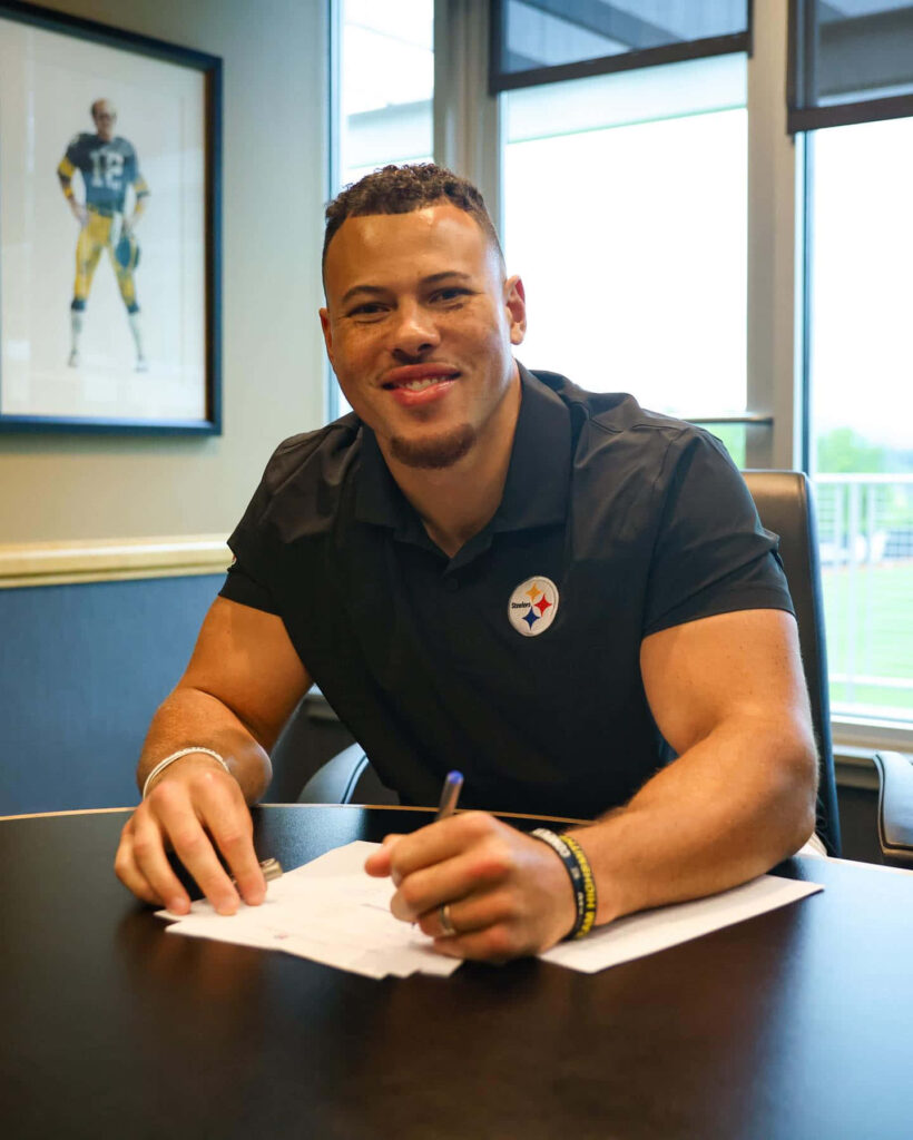Alex Highsmith smiling and signing contract wearing Pittsburgh Steelers shirt football career moment Wallpaper