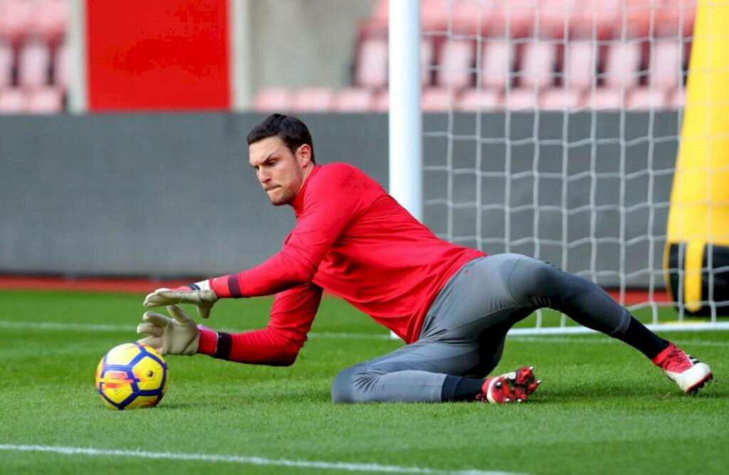 Alex McCarthy focused goalkeeper making a save during football training session on the pitch Wallpaper