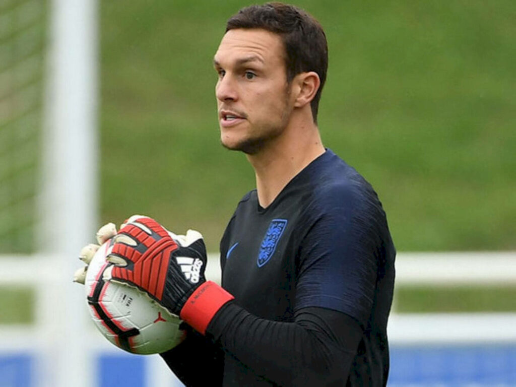 Alex McCarthy in goalkeeper gloves holding soccer ball focused during training session on field Wallpaper